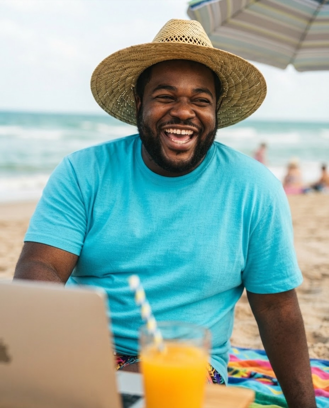 Laughing at the beach next to an open laptop